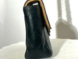 a black purse with a chain hanging from it ' s side