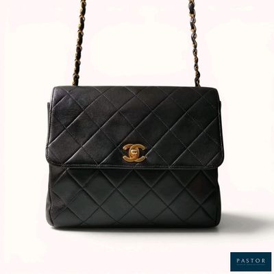 a black chanel bag with gold hardware on the handle
