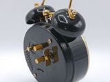 a black alarm clock sitting on top of a white table