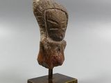 an image of a sculpture of a head on a wooden stand