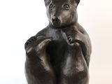 une statue représentant un ours assis sur le dos