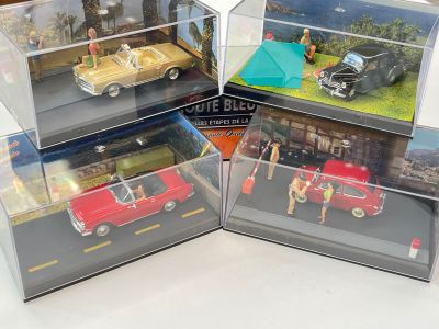trois modèles réduits de voitures dans une vitrine posée sur une table