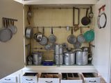 many pots and pans on the shelves in this kitchen