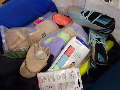 a suitcase filled with clothes and shoes on the floor