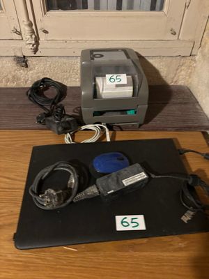un ordinateur portable posé sur un bureau, avec une imprimante posée dessus