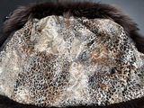 a leopard print hat with a fur collar on a black surface