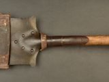 an old axe with a wooden handle on a gray surface