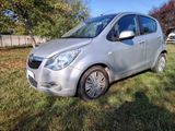 a picture of a small silver car parked in the grass