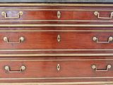 an antique chest of drawers with marble top and brass handles