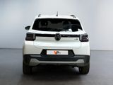 the rear end of a white car parked in a room