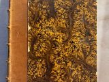 un vieux livre à la couverture brune posé sur une table