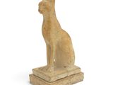 an image of a statue of a cat sitting on top of a stone block