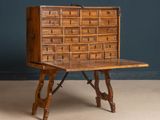 une vieille commode en bois posée sur une table en bois
