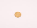 une petite pièce d'or sur un fond blanc