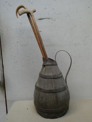 un arrosoir en métal avec un manche en bois posé sur une table