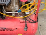 a red air compressor sitting on top of a pallet
