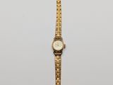 an image of a gold wrist watch on a white surface