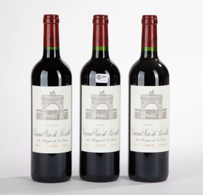 trois bouteilles de vin rouge posées l'une à côté de l'autre sur une surface blanche