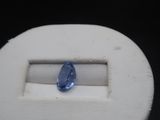 a blue sapphire in a white box on a black surface