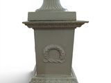 a white vase with a wreath on it sitting on a pedestal