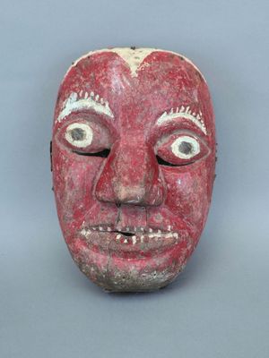 une image représentant un masque rouge avec un visage blanc sur fond gris