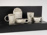 a black and white photo of a display of coffee cups and mugs