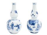 une paire de vases bleus et blancs ornés de personnages sur fond blanc