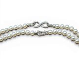 two strands of white pearls with silver clasps on a white background