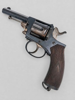 gros plan d'un revolver sur une surface blanche