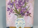 tableau représentant des fleurs violettes dans un vase blanc posé sur une table en bois