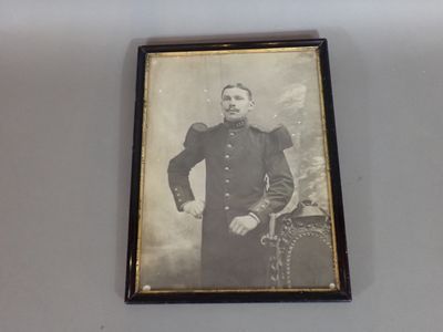 an old photo of a man in a military uniform is hanging on a wall