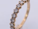 a close up of a gold ring with a row of diamonds