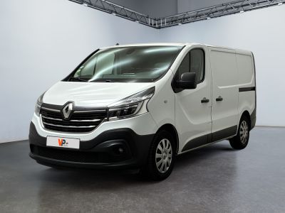 La camionnette blanche est garée dans une grande pièce aux murs blancs.