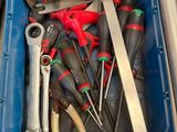 de nombreux outils dans une boîte bleue posée sur une table