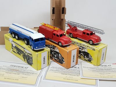 quatre camions de pompiers miniatures posés sur une boîte en carton