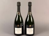 deux bouteilles de champagne posées l'une à côté de l'autre sur une table