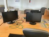 two computer monitors sitting on a desk with a keyboard and mouse