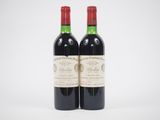 deux bouteilles de vin rouge posées l'une à côté de l'autre sur une surface blanche