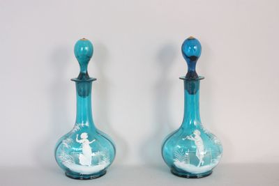 deux vases en verre bleu ornés de motifs blancs