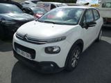 une Citroën blanche garée sur un parking à côté d'autres voitures