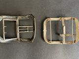 two metal buckles that are on a table