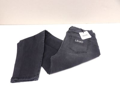 un jean noir posé sur une table blanche