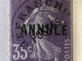 un vieux timbre violet sur lequel figure une femme tenant un panier de fleurs