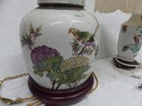 a white vase with a bird on it next to a lamp