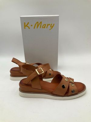 une paire de sandales marron ornées de boucles dorées