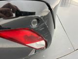 a person cleaning a car ' s tail light with a brush