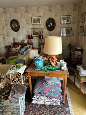un salon où le sol est encombré d'objets