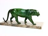 statue d'une panthère verte posée sur un socle en marbre
