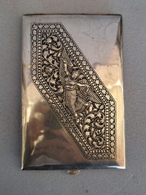 an antique silver cigarette case with a design on the front