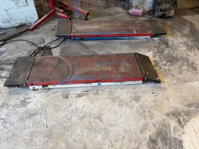 two pieces of metal laying on the floor in the garage